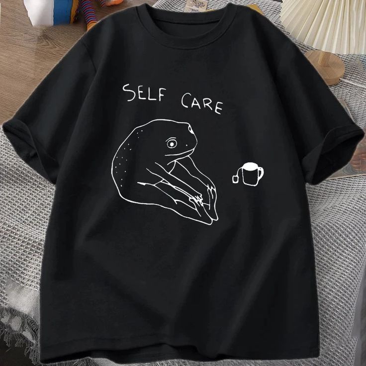 Cute black t-shirt with a simple frog drawing and “Self Care” caption, ideal for casual or aesthetic wear.