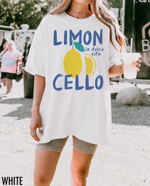 White oversized t-shirt with a lemon graphic and text “Limoncello – la dolce vita” in blue and yellow
