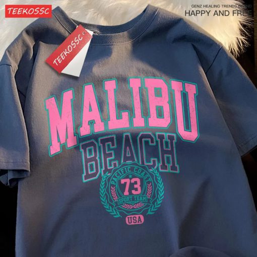 Navy unisex t-shirt featuring Malibu Beach retro-style print in varsity font with pink and teal colors.