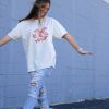 Beige t-shirt featuring a group of hand-drawn red goldfish in a minimalist, sketch-style design