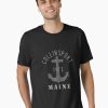 Black T-Shirt featuring “Collinsport 1972 Maine” text and a grey anchor graphic, modeled by a young man.