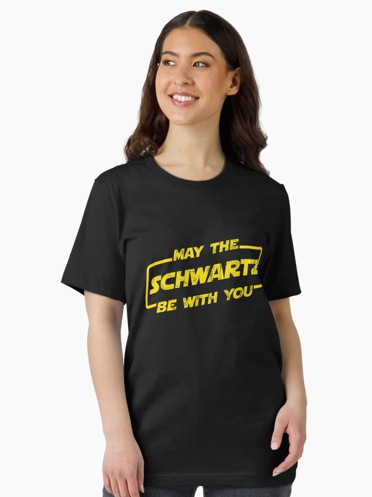 Black T-shirt with distressed yellow “May The Schwartz Be With You” text in sci-fi parody font.