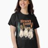 Women Black t-shirt featuring three cartoon ghost cowgirls in a desert scene with “Howdy Ghouls” text, worn by male model