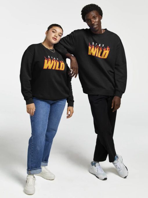 Black Sweatshirt with “Stay Wild” flame-text design in yellow and red, worn by a smiling male model
