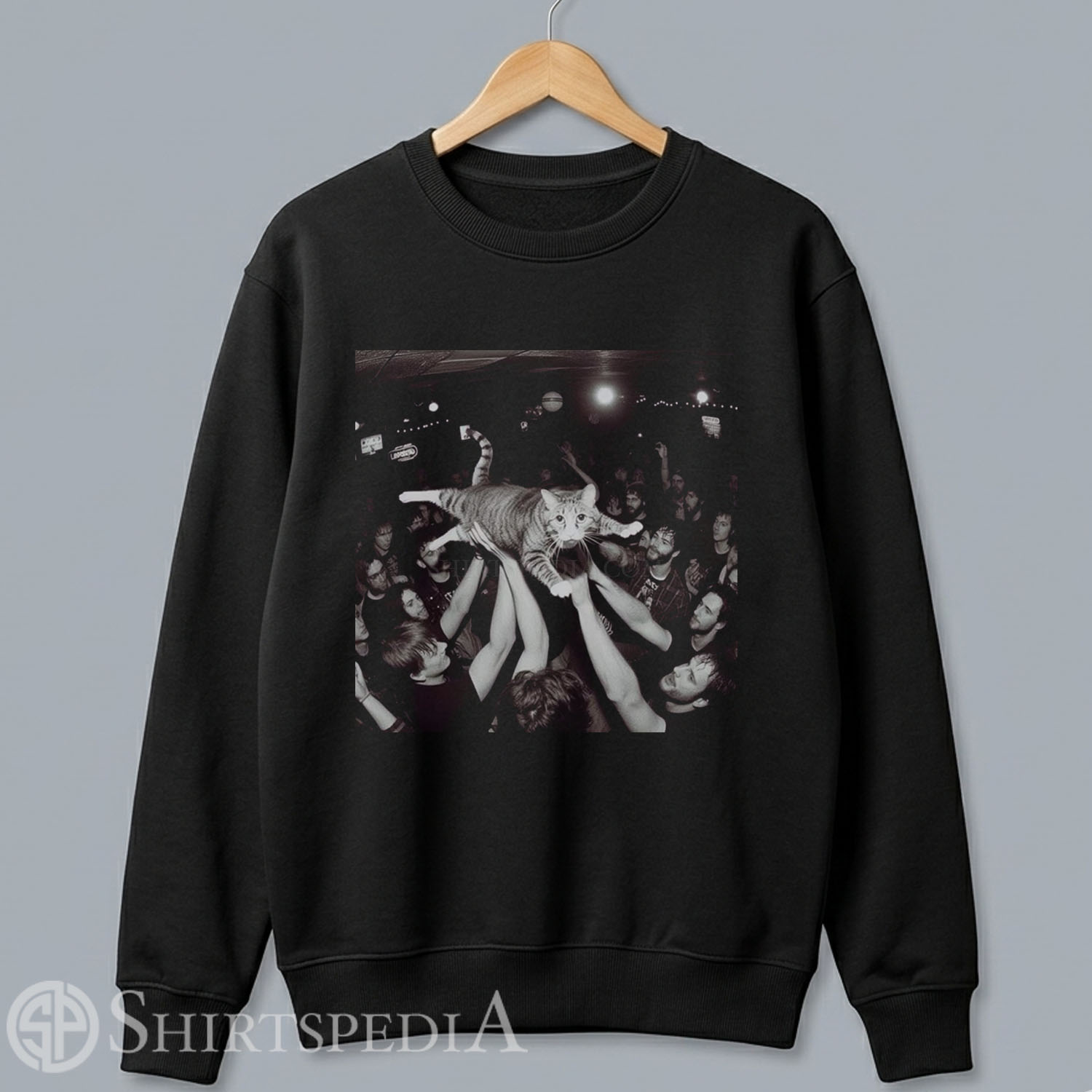 Unisex black crewneck pullover sweatshirt featuring a large central graphic of a crowd-surfing cat at a live rock concert.